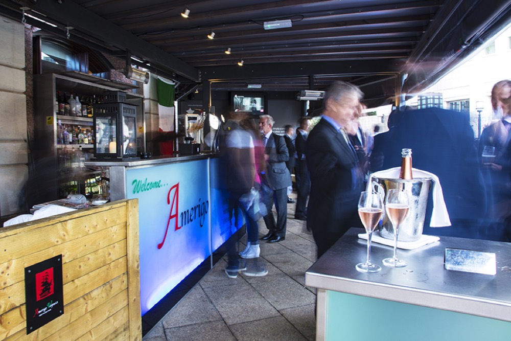 The alfresco bar at Amerigo Vespucci, an illuminated 'Welcome Amerigo' bar with prosecco on ice and an Italian flag
