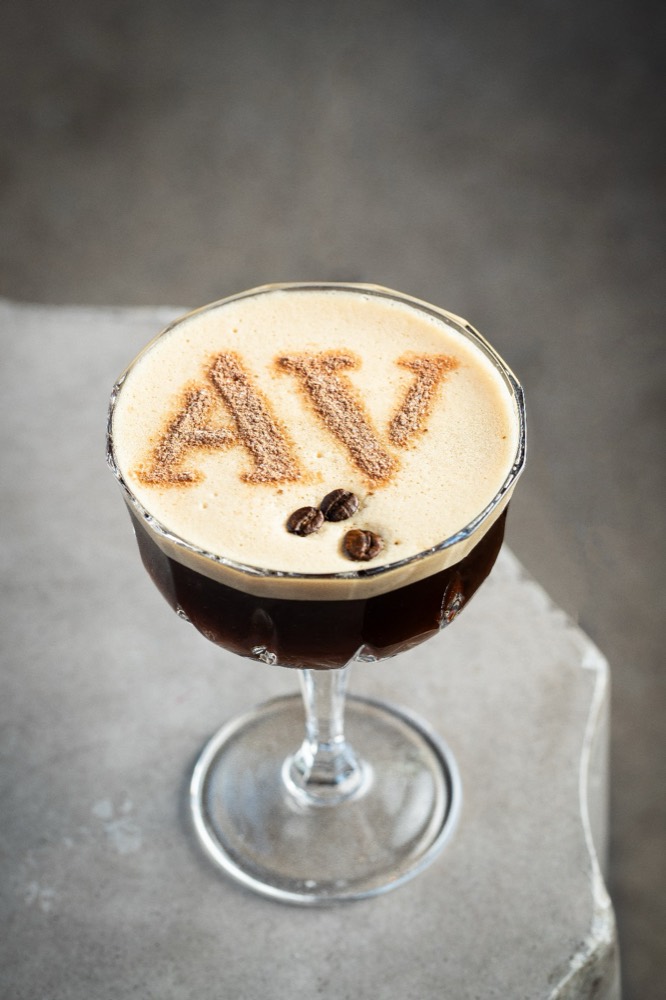 Espresso martini with the letters AV dusted onto the foam