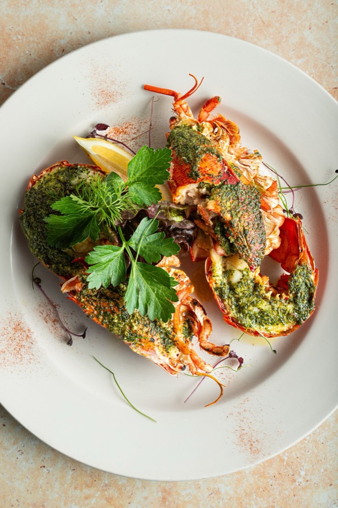 Grilled lobster halves dressed with herb butter, parsley and lemon